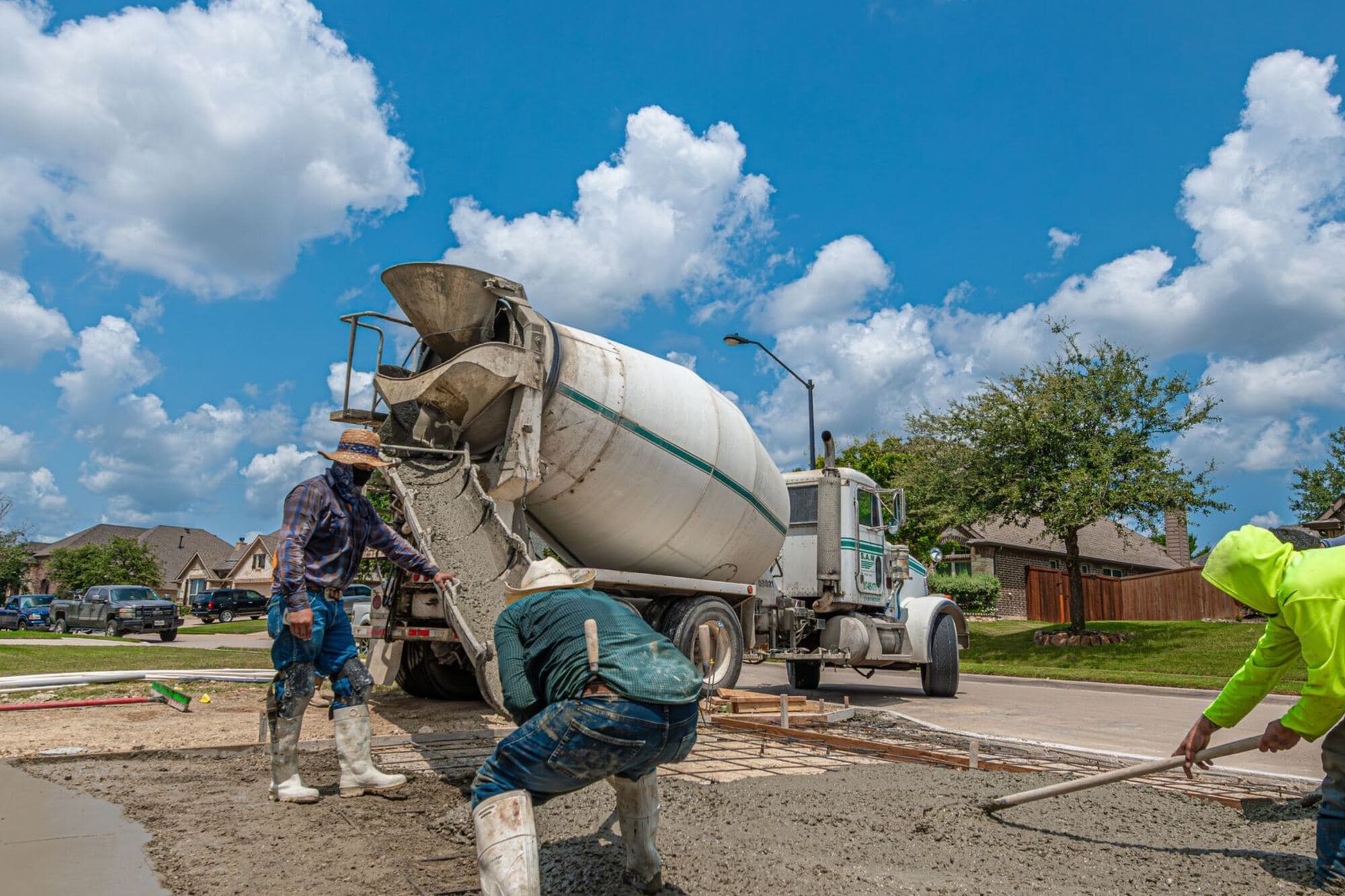Crew pouring a driveway from a mixer truck